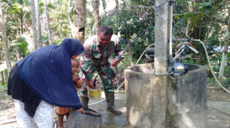 Babinsa Serda Bambang Bantu Orangtua Asuh Timba Air di Sumur