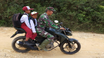 Sertu Muharamaini Antar Dua Siswa ke Sekolah