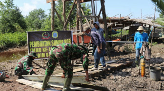 Bersama Warga, Satgas TMMD Labuhan Pering Pasang Lantai Sumur Bor