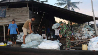 Kepedulian Satgas TMMD Bantu Warga Muat Kelapa ke Pompong