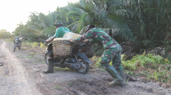 Lewati Jalan Licin, Satgas TMMD Bantu Dorong Motor Warga