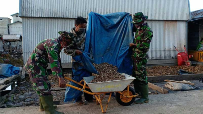 Anggota Satgas TMMD Bantu Warga Menjemur Pinang