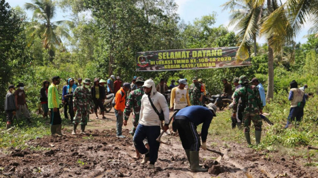 Anggota Satgas TMMD dan Masyarakat Kompak Perbaiki Jalan Rusak