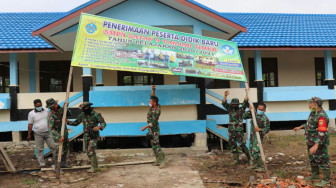 Satgas TMMD Bantu Pemasangan Banner Penerimaan Siswa/i Baru