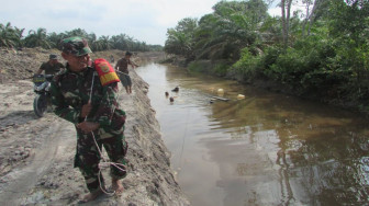 Satgas TMMD Seret Kayu Pelagas Melalui Sungai