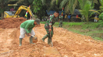 Warga dan Satgas TMMD Kuras Air di Timbunan Jalan